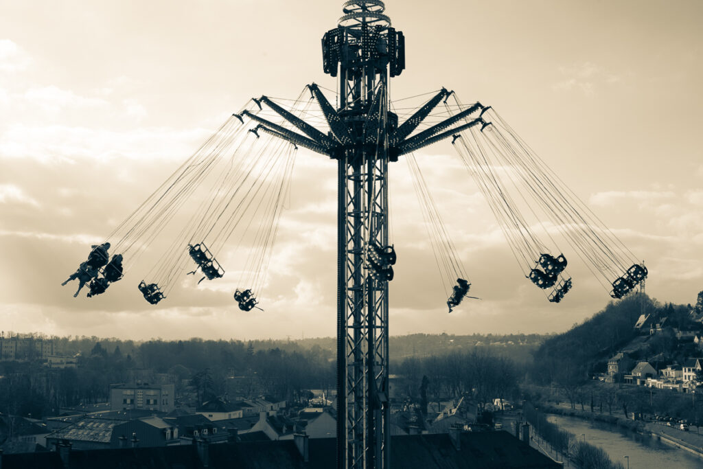 Photo d'une attraction de fête foraine qui permet de voler haut au-dessus de la ville